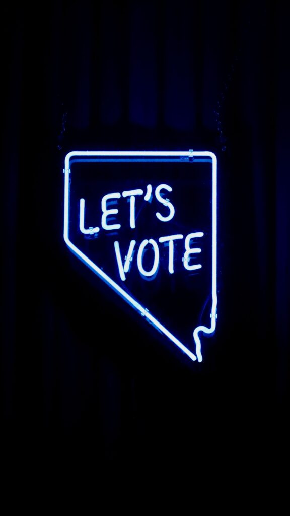 Bright neon 'Let's Vote' sign encouraging civic engagement.